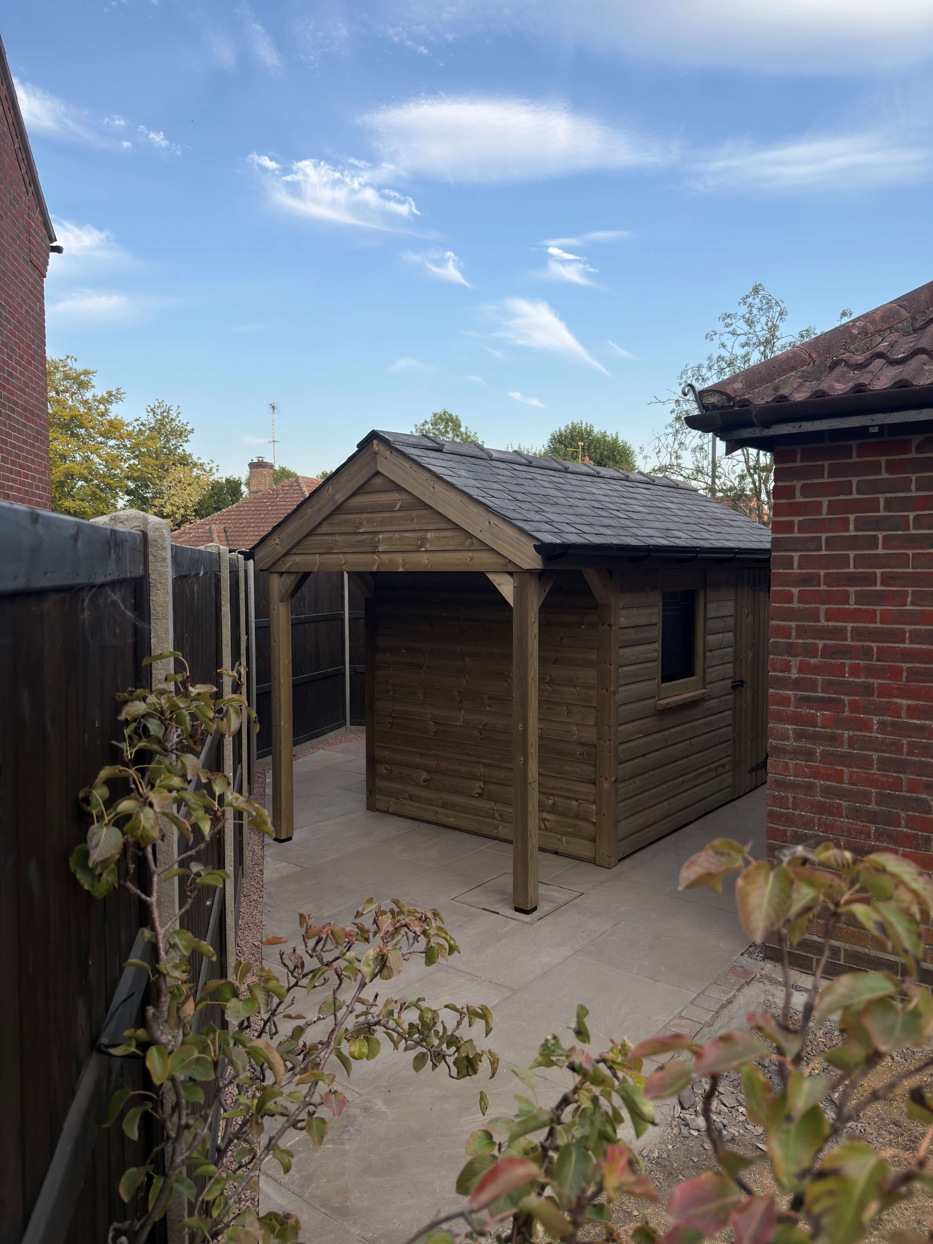 Covered wheelie bin storage area integrated into timber garden shed