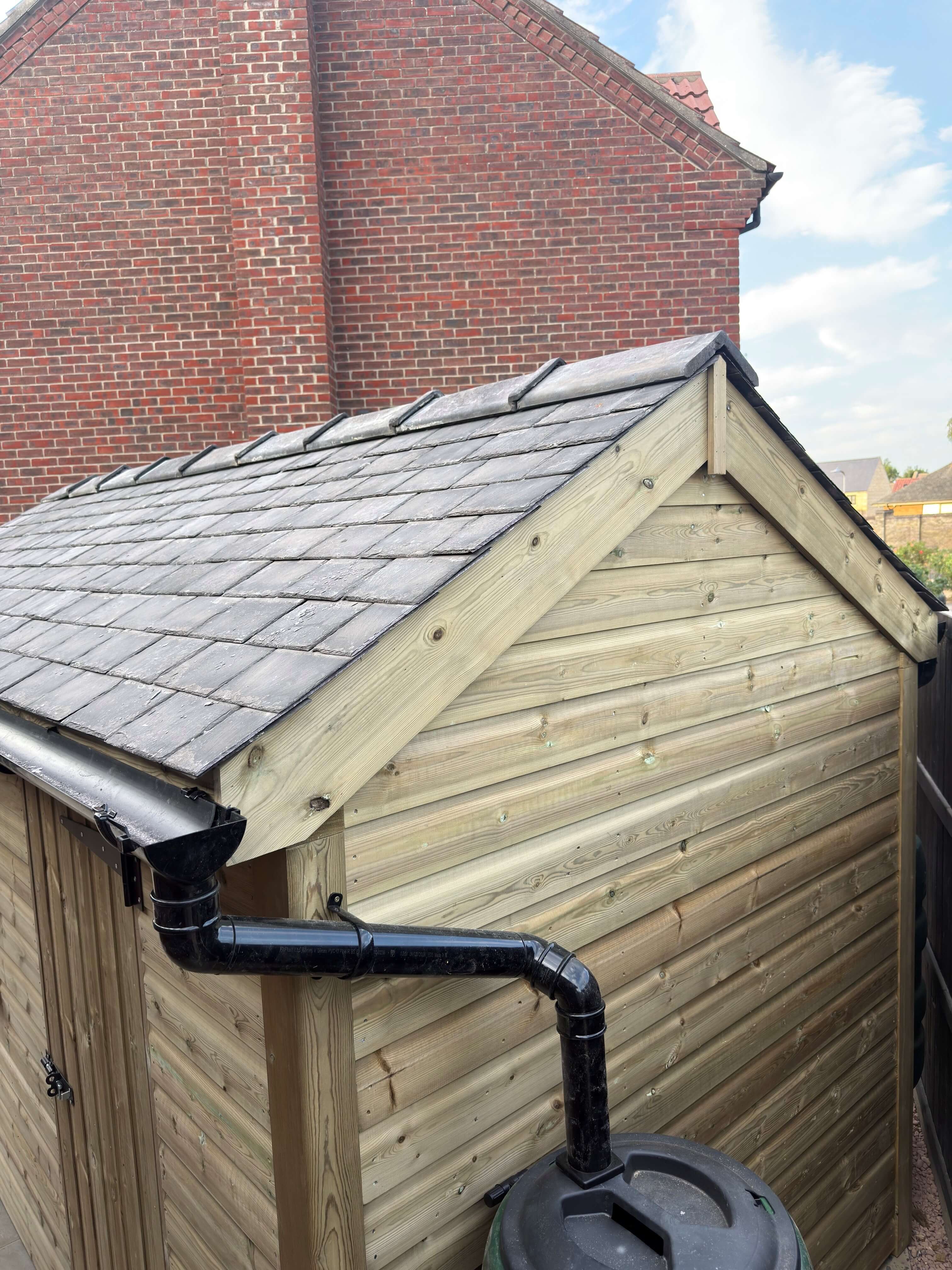 Reclaimed Welsh slate roof with clay ridge tiles on timber garden shed